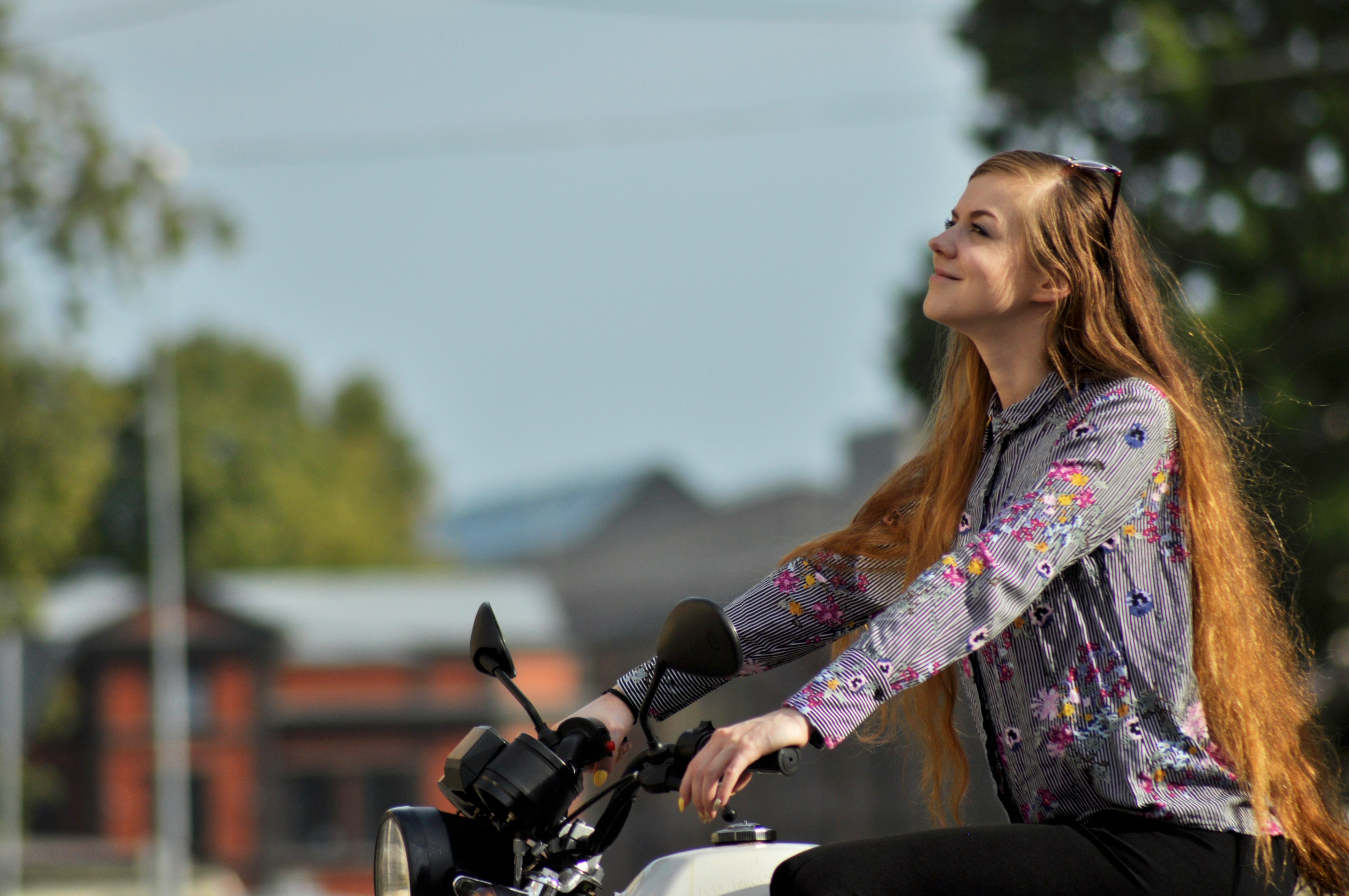 woman wearing purple floral long-sleeved top riding motorcycle